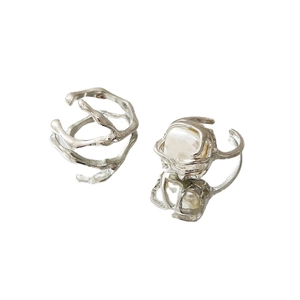 Irregular silver fluid ring set with faux pearls on a minimalist white reflective base