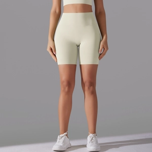 Detailed fit of high-waisted seamless yoga shorts in lemon yellow on a model