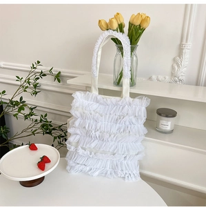 White ruffled mesh tote bag with cake skirt design in an elegant lifestyle setting