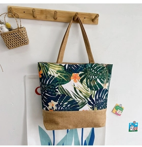 Detail of canvas tote bag with tropical leaf print and natural jute bottom panel
