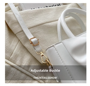 Close-up of a white leather bag featuring a gold metal buckle and neat stitching details