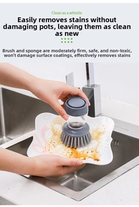 Gros plan d'une brosse de cuisine grise nettoyant une assiette en céramique blanche
