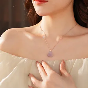 Rose gold necklace with lavender chalcedony Buddha pendant worn on a model neckline