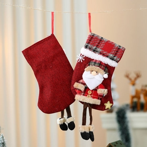Hängende rote Weihnachtssocken mit Plüsch-Weihnachtsmann und klassischen Karomustern