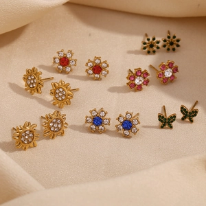 Detail of 18K gold plated flower and butterfly stud earrings with colorful zircons