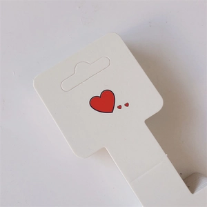 White jewelry display cards with red heart patterns and hanging holes for accessories