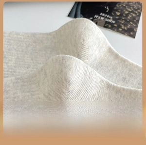 Close-up of the ergonomic 3D heel design on soft beige knit cotton crew socks