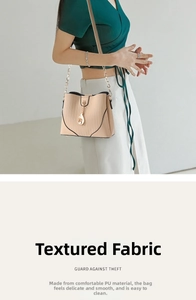 Detail of beige square crossbody bag with gold chain and dolphin charm accessory