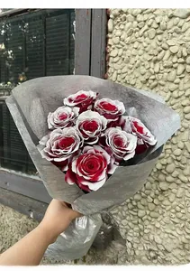 Detail of red roses with frosted white snow edges in premium gray florist wrapping paper
