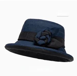 Détail du chapeau de soleil bleu marine avec fleur en tissu décorative et ruban noir chic