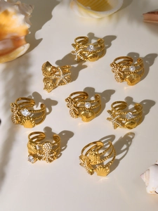 Detail view of 18k gold plated ocean theme rings with starfish and seashell charms