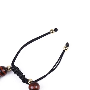 Macro detail of natural red tiger eye stone beads and black braided adjustable cord