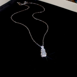 Vue détaillée d'un collier pendentif calebasse translucide orné de cristaux brillants
