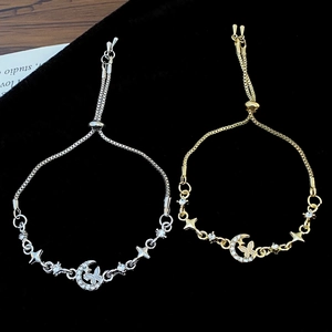 Close-up of gold and silver crystal moon bracelets with butterfly and star charms