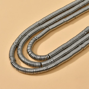 Close-up of industrial style silver spring metal coil strands on layered necklace