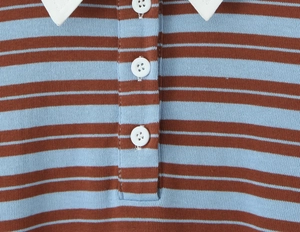 Detail of the white contrast collar and brown and blue striped knit fabric with three buttons
