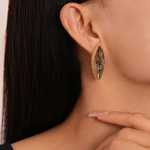 Close-up of marquise cut water drop earrings with gold frame and sparkling brown stones