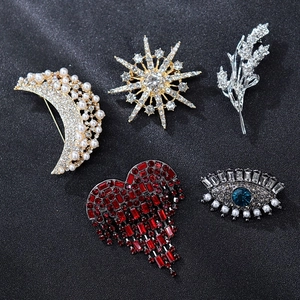 Flat lay of vintage style brooches with pearls and crystals in star and heart shapes