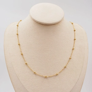 Elegant gold titanium steel beaded chain necklace displayed on a white neck bust model