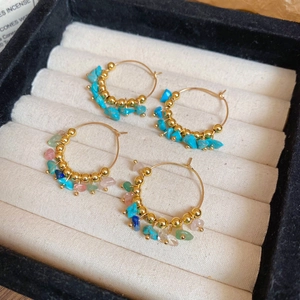 Detail of bohemian gold hoop earrings with turquoise and multicolor crushed stones