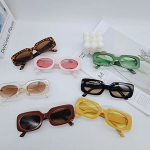Flatlay of retro rectangular sunglasses in various colors on a modern white background