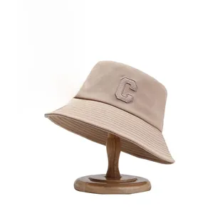 Détail d'un chapeau bob en toile kaki avec bord surpiqué et lettre C brodée de face