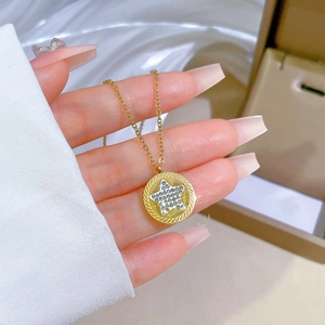 Macro shot of gold star-pendant necklace featuring a diamond-set circular charm