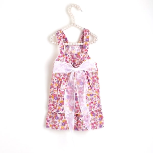 Detail of floral pet dress with lace bow on white pearl hanger for small dogs and cats