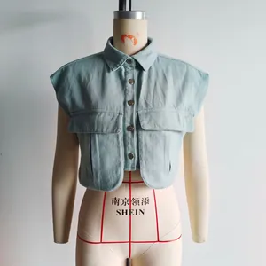 Détail du gilet en jean bleu clair avec col polo et grandes poches cargo