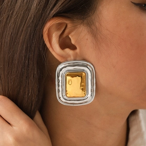 Two-tone gold and silver square geometric earrings with hammered texture on model