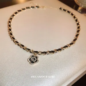 Gold-plated camellia pendant necklace with leather woven chain and sparkling zircon stones