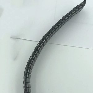 Detail of flexible black stainless steel watch strap links with polished finish