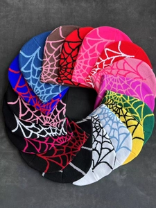 Variety of knitted beanies with spider web jacquard patterns in various colors