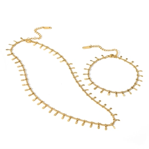 Detailed macro of gold-plated stainless steel jewelry set with dangling rectangle tassels
