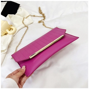 Detail of rose red clutch bag with pleated texture and gold metal trim handle