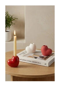 Minimalist ceramic heart-shaped candle holders in red and white on a wooden table