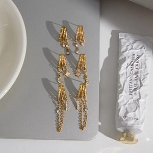 Vue détaillée de boucles d'oreilles créoles C à trois couches avec pompons en zircon