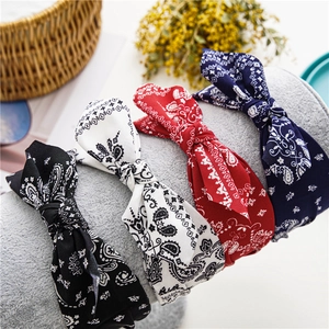 Close-up of four paisley knotted headbands in black, white, red, and navy blue on a display