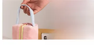 Dettaglio della borsa in velluto rosa con manico azzurro spesso e cerniera gialla vivace