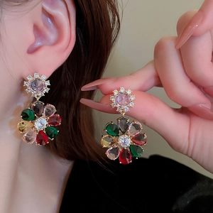 Close-up of vintage gold flower earrings with colorful teardrop-shaped zircon crystals