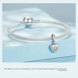 Macro view of S925 silver mesh bracelet featuring a heart pendant with starburst engraving