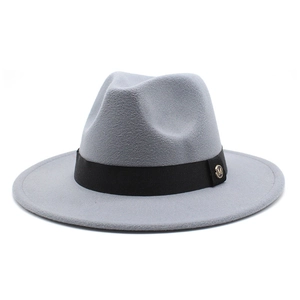 Close-up of black ribbon band with golden M emblem on grey wool fedora hat
