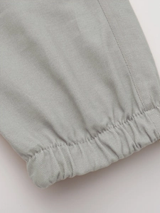 Detail of grey men's cargo pants showing high-quality elastic cuffs and durable stitching
