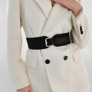 Detail of wide black elastic waist belt with a golden square buckle on white blazer