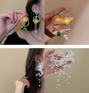 Detail of floral and lace pearl tassel earrings showing both yellow and white designs