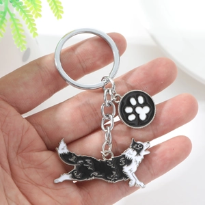 Detail of Border Collie metal keychain with black paw print charm and silver link chain