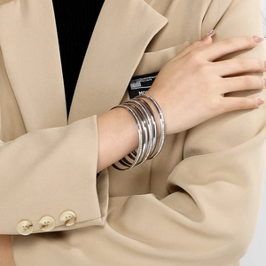 Close-up of layered 5.5mm silver and rose gold bangles with cubic zirconia on wrist