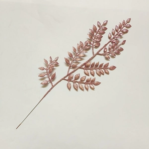 Vista dettagliata di foglie natalizie glitterate oro rosa per decorazioni floreali festive