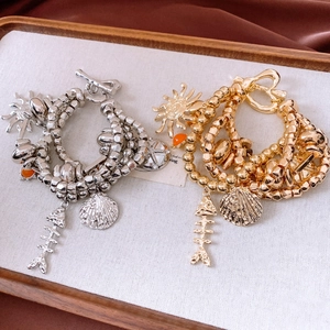 Detailed macro view of vintage multi-layer bracelets with sun, shell and fishbone pendants
