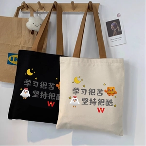Detail view of canvas tote bags with cartoon prints and nylon woven handles hanging on wall